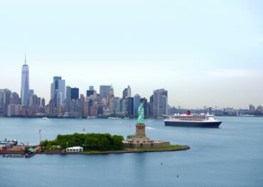 Die Queen Mary 2 fährt in New York an der Freiheitsstatue vorbei